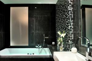 a bathroom with a bath tub and a sink at Sani Polyastron Hotel & Spa in Sani Beach