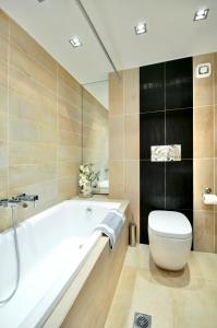 a bathroom with a white tub and a toilet at Sani Polyastron Hotel & Spa in Sani Beach