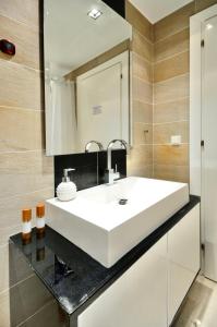 a bathroom with a white sink and a mirror at Sani Polyastron Hotel & Spa in Sani Beach