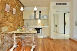 a kitchen with a stone wall and a table and chairs at Sani Polyastron Hotel & Spa in Sani Beach +37 photos