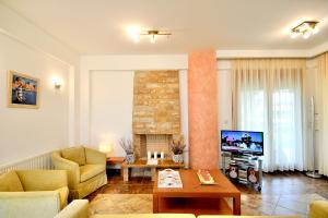 a living room with a couch and a tv at Sani Polyastron Hotel & Spa in Sani Beach