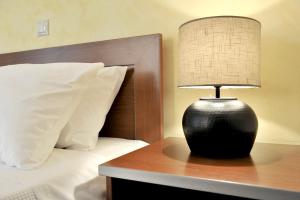 a black lamp sitting on a table next to a bed at Sani Polyastron Hotel & Spa in Sani Beach