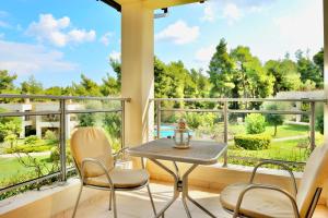 a balcony with a table and chairs and a large window at Sani Polyastron Hotel & Spa in Sani Beach