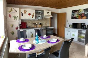 a kitchen with a wooden table with purple plates on it at Haus Ruhland in Tiefenbach