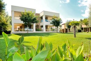 a house with a green lawn in front of it at Sani Polyastron Hotel & Spa in Sani Beach