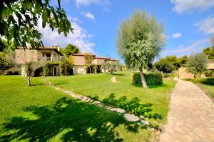 a house with a green yard with a tree at Sani Polyastron Hotel & Spa in Sani Beach