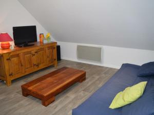een woonkamer met een bed en een houten tafel bij Gîte Saint-Nicolas-des-Motets, 3 pièces, 4 personnes - FR-1-381-145 in Saint-Nicolas-des-Motets