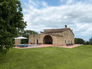 a large stone building with a pool in front of it at Mas Trobat in Juià