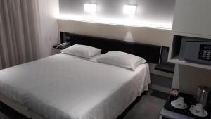 羅馬的住宿－Crosti Hotel，一间卧室配有一张带两个枕头的床和一台微波炉