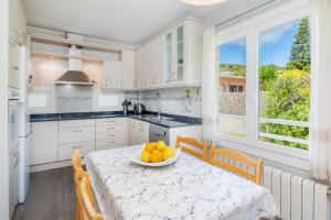 a kitchen with a table with a bowl of oranges on it at Casa Luz in Cala Ratjada