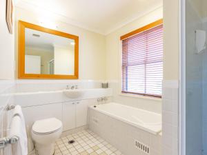 a bathroom with a tub and a toilet and a sink at Villa 2br Riesling Villa located within Cypress Lakes Resort in Pokolbin +19 photos