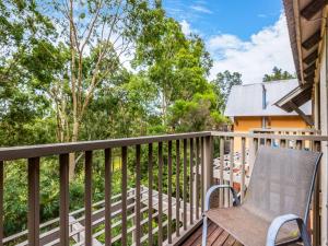 una terraza con una silla y una casa en Villa 2br Riesling Villa located within Cypress Lakes Resort, en Pokolbin