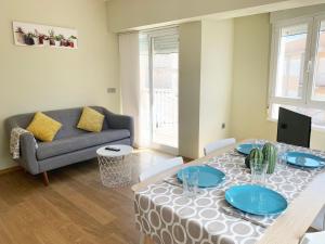 ein Wohnzimmer mit Tisch und Couch in der Unterkunft Apartamentos Castillo Peñiscola 3000 in Peñíscola