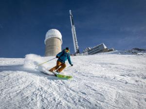 a man is skiing down a snow covered slope at Studio sur les pistes in Bagnères-de-Bigorre