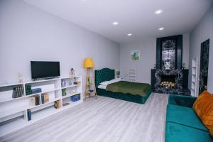 a bedroom with a couch and a bed and a fireplace at Layla's Apartment in Tbilisi City +43 photos