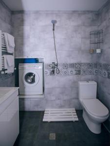a bathroom with a washing machine and a toilet at Ardoni Hotel in Tbilisi City