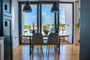 a dining room with a table and chairs and a large window at Vanni apartment in Zadar
