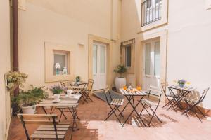 a patio with a bunch of tables and chairs at Dimore delle Zagare Ortigia in Siracusa