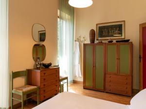 - une chambre avec une commode et un miroir dans l'établissement Villa Cipressi by Victoria Palace, à Pesaro