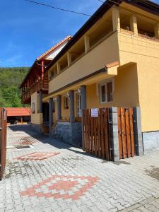 una casa con una puerta de madera y un patio de ladrillo en Rajni panzio en Praid