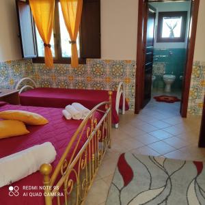 um quarto com uma cama e uma casa de banho com uma banheira em Baglio Cracchiolo da Tuzzo - Casa Fico D'India em San Vito lo Capo
