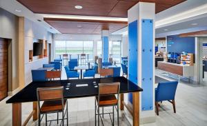 a dining room with blue chairs and a table at Holiday Inn Express & Suites Windsor East - Lakeshore by IHG in Lakeshore