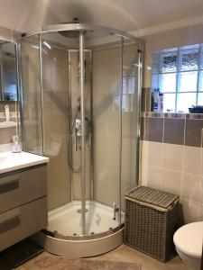 La salle de bains est pourvue d'une douche avec une porte en verre. dans l'établissement Chambon-sur-Lac, à Chambon-sur-Lac