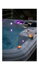 two glasses of wine sitting on a table in a pool at Holiday Home Casa Oliva II in Nerezine