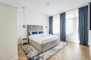 a bedroom with a large bed and blue curtains at Rya Residence Oradea in Oradea
