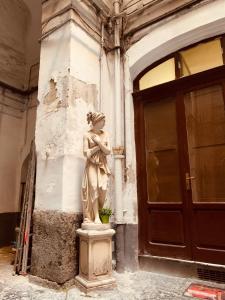 Una statua di una donna in piedi di fronte a un edificio di A Casa di Anna a Napoli