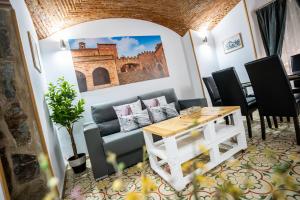 a living room with a table and a couch at Art & SUITE Apartment Cáceres in Cáceres