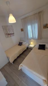 Un dormitorio con dos camas y una ventana en Holiday house BEDEM, en Marina