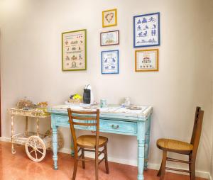 a blue desk with two chairs in a room at B&B A casa di Teresa in Olbia