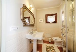 a bathroom with a sink and a toilet and a mirror at B&B A casa di Teresa in Olbia