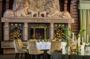 a dining room with a table and a fireplace at Park-Hotel Kidev in Chubynske