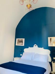 una camera blu con un letto bianco con una parete blu di A Casa di Anna a Napoli