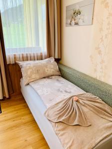 a small bed in a room with a window at Appartement Daniel 2 Kaprun-SUMMER CARD INCLUDED in Kaprun