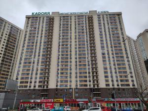 um grande edifício com uma placa em cima em Апартаменты в ЖК " 30я Жемчужина KADORR" em Liski