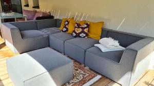 Un sofá azul con almohadas coloridas. en Jagd trifft Moderne & Boutique Jardin Ferienhaus, en Annaberg im Lammertal