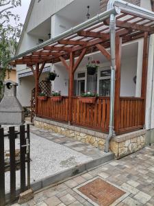 een houten pergola aan de zijkant van een huis bij Edina-ház in Balatonboglár