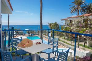 einen Tisch und Stühle auf einem Balkon mit Meerblick in der Unterkunft Alsol Los Caribes 1 in Playa del Ingles