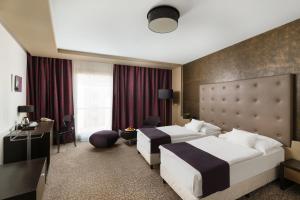 Postel nebo postele na pokoji v ubytování Corso Hotel Pécs