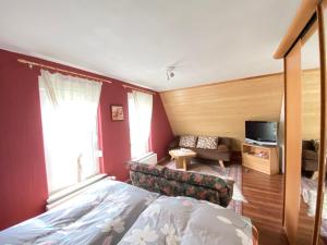 1 dormitorio con cama, sofá y TV en Ferienhaus Hennig en Bersteland