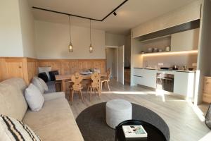 a living room and kitchen with a couch and a table at Avista Apartments Sky in Merano