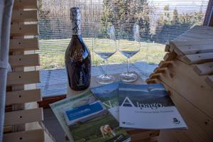 a bottle of wine and two glasses on a box at DolomitiBel Chalet in Tambre dʼAlpago