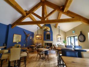 a dining room with blue walls and wooden tables and chairs at The Pickled Pheasant in Holmfirth
