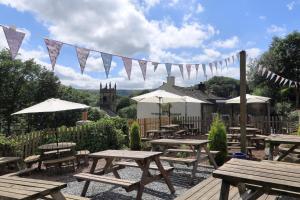 a group of picnic tables and umbrellas with flags at The Pickled Pheasant in Holmfirth