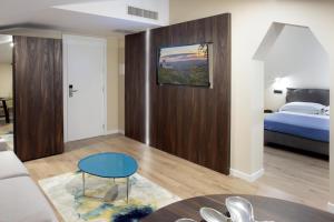 a living room with a bed and a blue table at Hotel Porta Nuova in Assisi