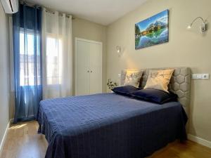 a bedroom with a bed with a blue comforter at COLIBRI Cómodo, bonito, céntrico in Calpe