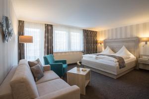 ein Hotelzimmer mit einem Bett und einem Sofa in der Unterkunft Hotel Garni Fürst von Waldeck in Willingen